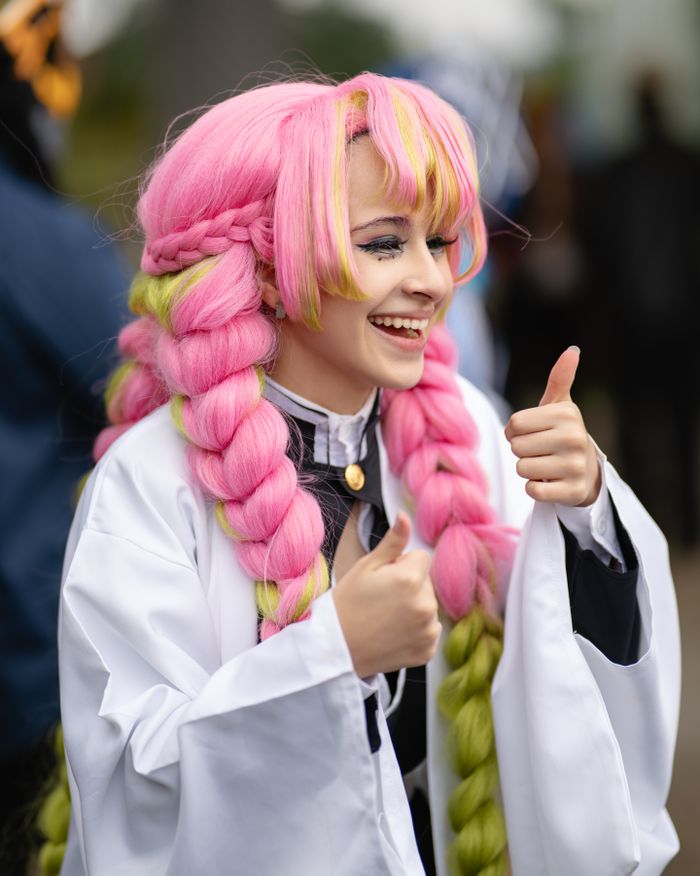 Cosplay enthusiast in vibrant pink wig and costume at an anime convention in San José, Costa Rica.